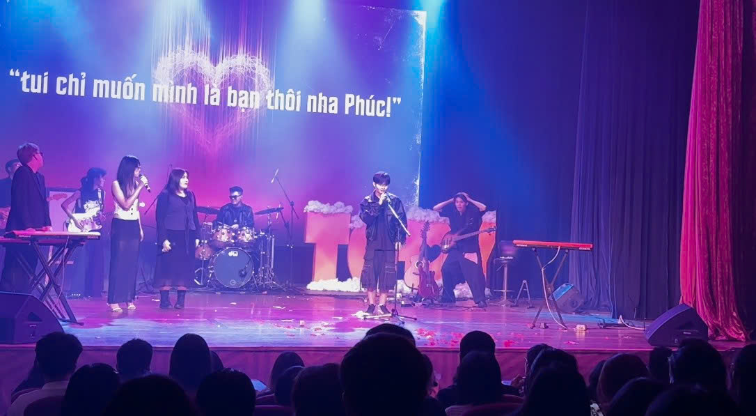 Thai Son Ngo reacting in the background during a TGDY 13 performance