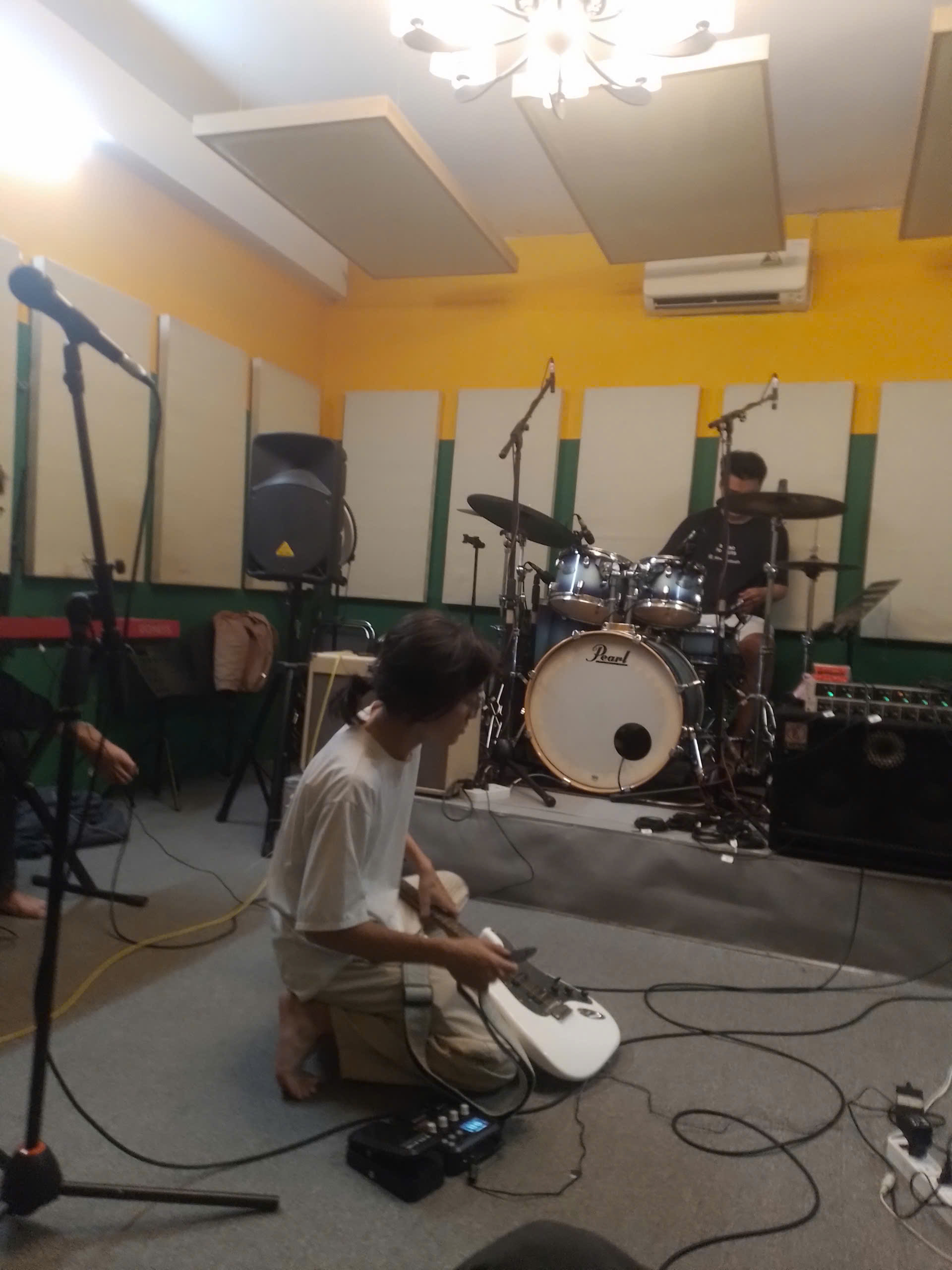 A usual TGDY practice session with band members setting up in the rehearsal room
