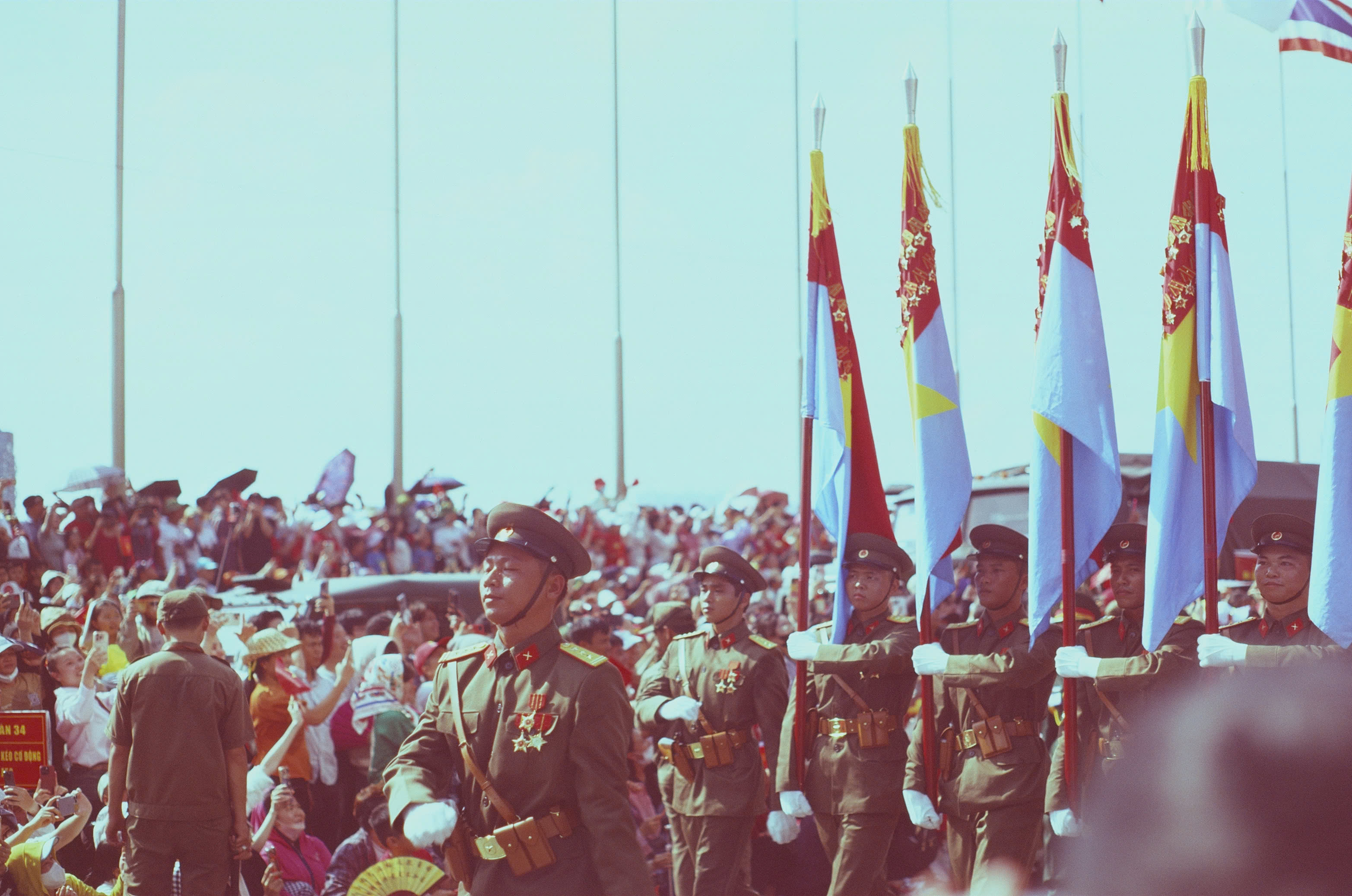 Vietnamese military flag bearers marching past spectators during the full-dress rehearsal