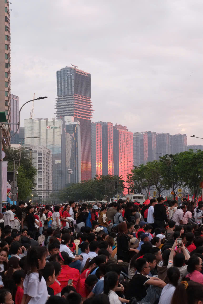 A dense crowd gathered along a central Saigon street for the parade rehearsal